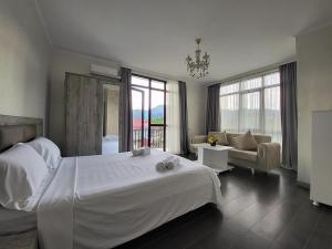 - une chambre avec un grand lit blanc et un canapé dans l'établissement MITE Hotel, à Chakvi