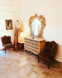 Megás Limniónas的住宿－陽光公寓，一间设有梳妆台、镜子和两把椅子的房间