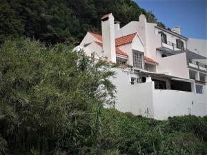 a white house on the side of a hill at Casa de férias com vistas deslumbrantes in Porto Formoso