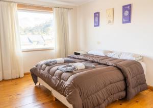 a bedroom with two beds and a large window at Hotel Nuke Piren in Caviahue