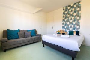 Habitación con cama y sofá en Villa Palmera, en Saint-Aignan