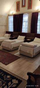 Cette chambre comprend plusieurs lits installés au même étage. dans l'établissement ŞarkÇırağan Konak Boutique Hotel, à Şanlıurfa