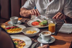 a man eating food on a table with plates of food at Iberostar Waves Slavija in Budva