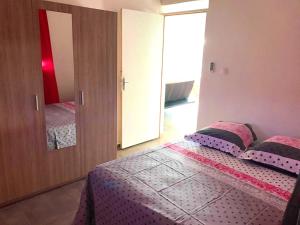 a bedroom with a large bed with a mirror at Villa enchanteresse au Moule avec piscine privée in Le Moule +10 photos