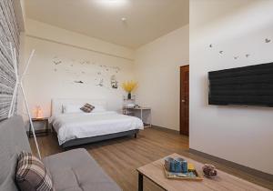 Schlafzimmer mit einem Bett und einem Flachbild-TV in der Unterkunft Twilight Riverside Homestay in Wujie