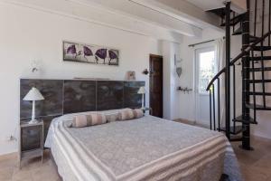 1 dormitorio con 1 cama grande y una escalera en Mas Nina Rosa, en Mazan