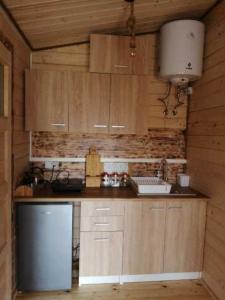 a kitchen with wooden cabinets and a white refrigerator at Nowy domek letniskowy in Pisz