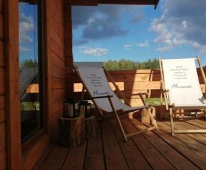 a deck with a chair and a sign on a porch at Nowy domek letniskowy in Pisz