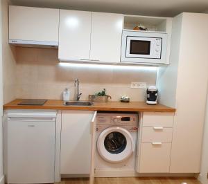 a kitchen with a washing machine and a microwave at Road Sierra 95 Habitación privada con baño y zona de cocina in Granada