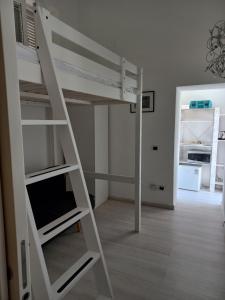 a white bunk bed with a ladder in a room at Casetta Iacono camera Pithecusa in Ischia