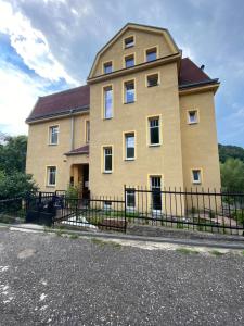 uma casa grande com uma cerca em frente em Apartmány U Viaduktu 46 em Ústí nad Labem