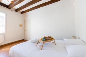 een witte slaapkamer met 2 bedden en een tafel bij Perruche in Saint-Aignan