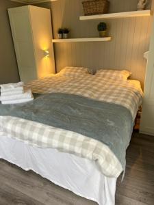 uma cama com um cobertor xadrez num quarto em Koselig leilighet sentralt i Stavern em Stavern