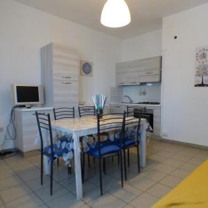 a kitchen and dining room with a table and chairs at Complesso Oasi in Tirrenia