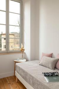 a bedroom with a bed with a table and two windows at Domaine et Château de Valinches in Marols