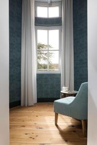 a living room with a chair and a window at Domaine et Château de Valinches in Marols