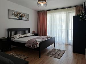 une chambre avec un lit et une grande fenêtre dans l'établissement APARTAMENT ANTIK No6 ALBA IULIA, à Alba Iulia