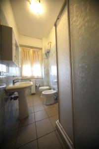 La salle de bains est pourvue de 2 toilettes, d'un lavabo et d'une douche. dans l'établissement Complesso Oasi, à Tirrenia