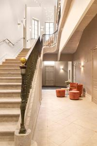 - un escalier dans un bâtiment avec des chaises orange dans l'établissement Domaine et Château de Valinches, à Marols