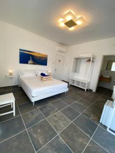 ein Schlafzimmer mit einem weißen Bett und Fliesenboden in der Unterkunft L'altra LulÍa in Otranto