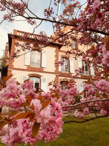 une maison avec des fleurs roses devant elle dans l'établissement La Villégiature, à Coutances