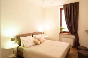 Schlafzimmer mit einem Bett mit weißer Bettwäsche und einem Fenster in der Unterkunft Dimora al Borgo in Verona
