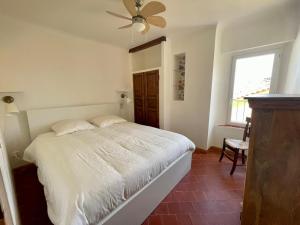 sypialnia z białym łóżkiem i wentylatorem sufitowym w obiekcie La Maison de Lily, cosy dans le Vieux-Hyères, parking gratuit w Hyères