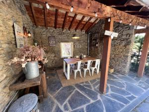 a room with a table and chairs in a stone building at MESON DU BONHEUR in Osséja
