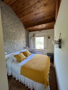 a bedroom with a large bed in a stone wall at MESON DU BONHEUR in Osséja