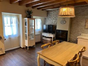 a dining room with a table and a television at MESON DU BONHEUR in Osséja