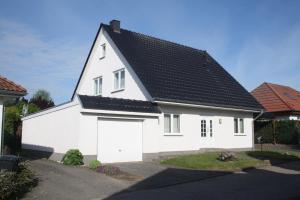 une maison blanche avec un toit noir dans l'établissement Wiesenblick, à Loitz
