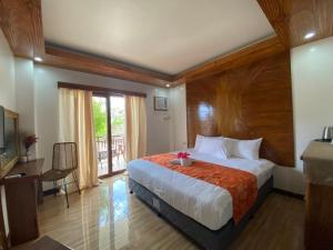 sypialnia z dużym łóżkiem i balkonem w obiekcie Puyo Suites Homestay w mieście General Luna