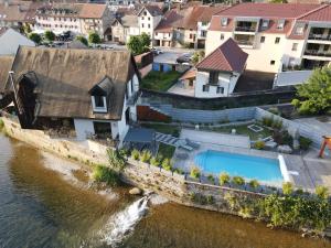 an aerial view of a house next to a river at demoiselle Loue in Ornans