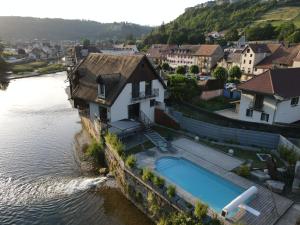 a house with a swimming pool next to a river at demoiselle Loue in Ornans