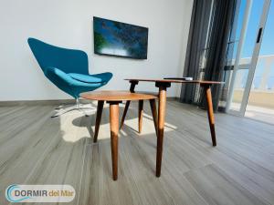 a table and a blue chair in a room at Dormir del Mar in La Marina