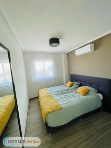 a bedroom with a bed and two windows at Dormir del Mar in La Marina