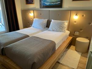 two beds in a hotel room next to a window at ANGELO in Koper