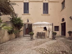 Cori的住宿－Agriturismo Castello Santa Margherita，帐篷下配有桌椅的建筑