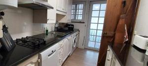 a kitchen with white cabinets and a stove top oven at Casa de férias com vistas deslumbrantes in Porto Formoso