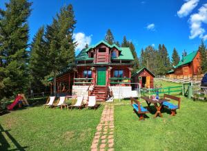 a house with chairs and a table in front of it at Guest House Milena in Žabljak