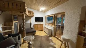 a living room with a couch and a tv at Haizelrock in Kirchberg in Tirol