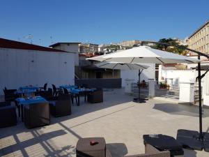 een patio met tafels en stoelen en een parasol bij Bed and Breakfast I Vicoletti Di Napoli in Napels