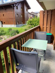 Una mesa y dos sillas en un balcón. en Location studio plein centre Les Carroz, en Les Carroz d'Araches