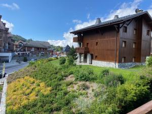 una casa en una colina al lado de una calle en Location studio plein centre Les Carroz, en Les Carroz d'Araches