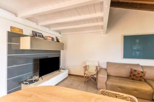 - un salon avec un canapé et une télévision dans l'établissement Maloma, à Peschiera del Garda