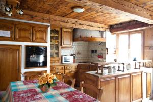 a kitchen with wooden cabinets and a table with flowers on it at GITE DES FUVES in Luisans