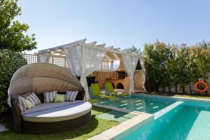 podwórko z basenem z krzesłem i pergolą w obiekcie Villa Green Mare w mieście Prínos