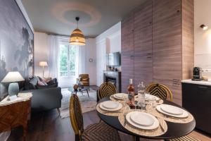 eine Küche und ein Wohnzimmer mit einem Tisch und Stühlen in der Unterkunft LE SHERWOOD - Magnifique T3 avec bureau in Villeurbanne