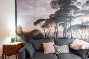 ein Sofa im Wohnzimmer mit einem Gemälde in der Unterkunft LE SHERWOOD - Magnifique T3 avec bureau in Villeurbanne