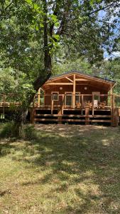 a large wooden cabin with a tree at Camping le Soleil in Vivario